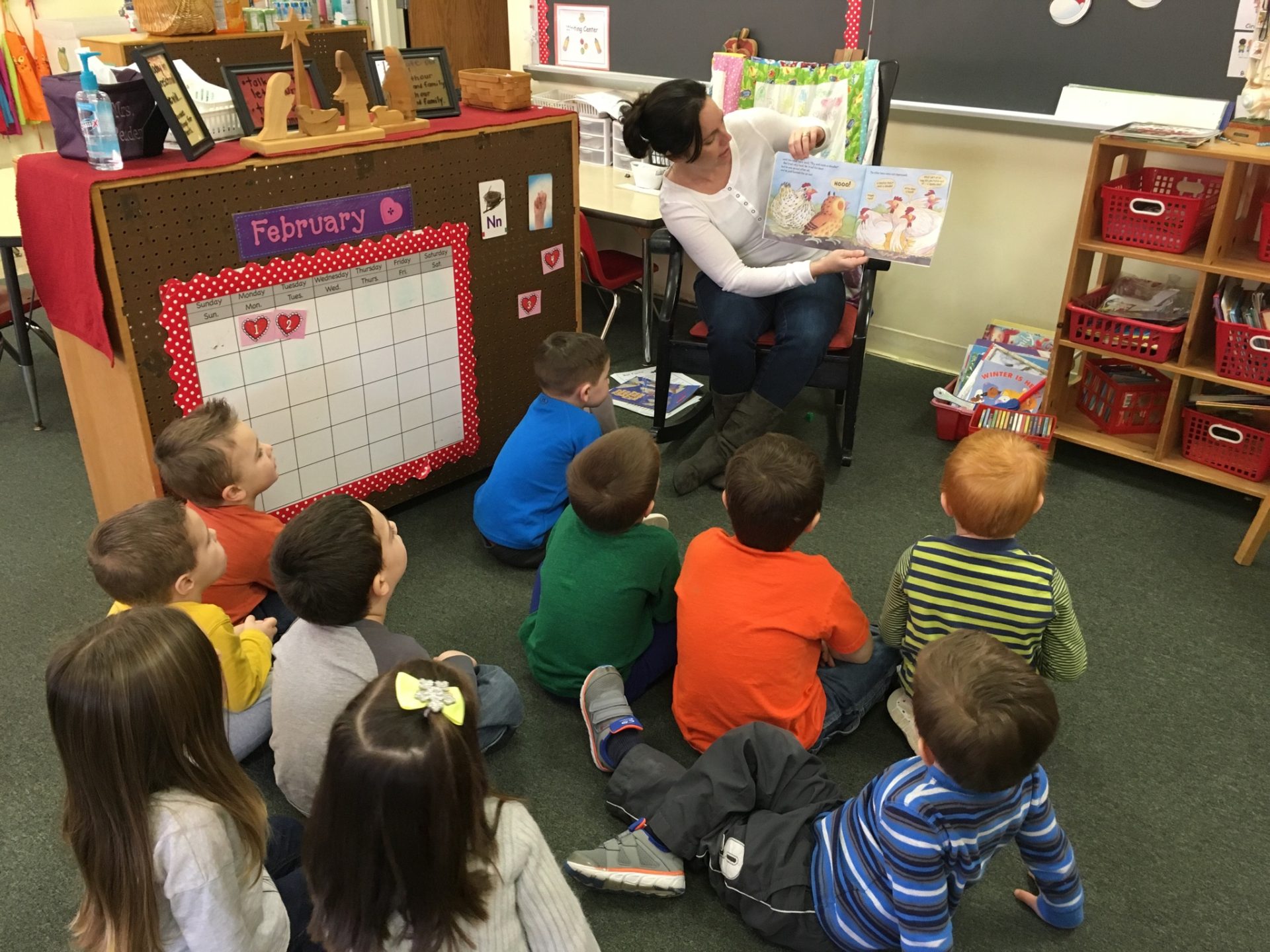 A parent reading to kids in a classroom